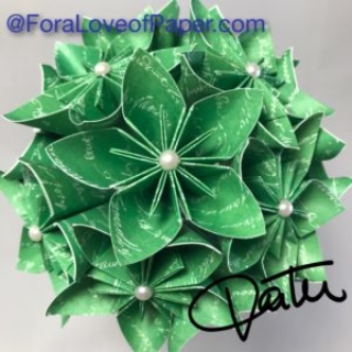 Paper flowers made from green paper with white script